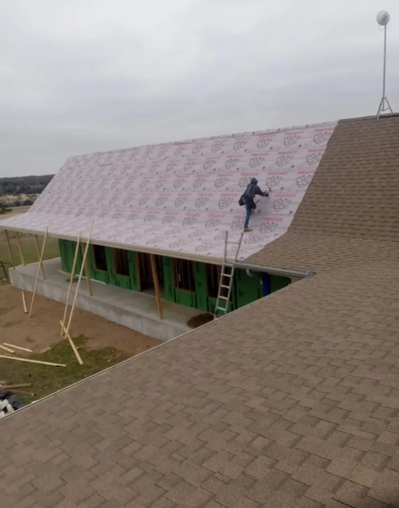 Worker preparing underlayment for a metal roof installation in Walnut Creek